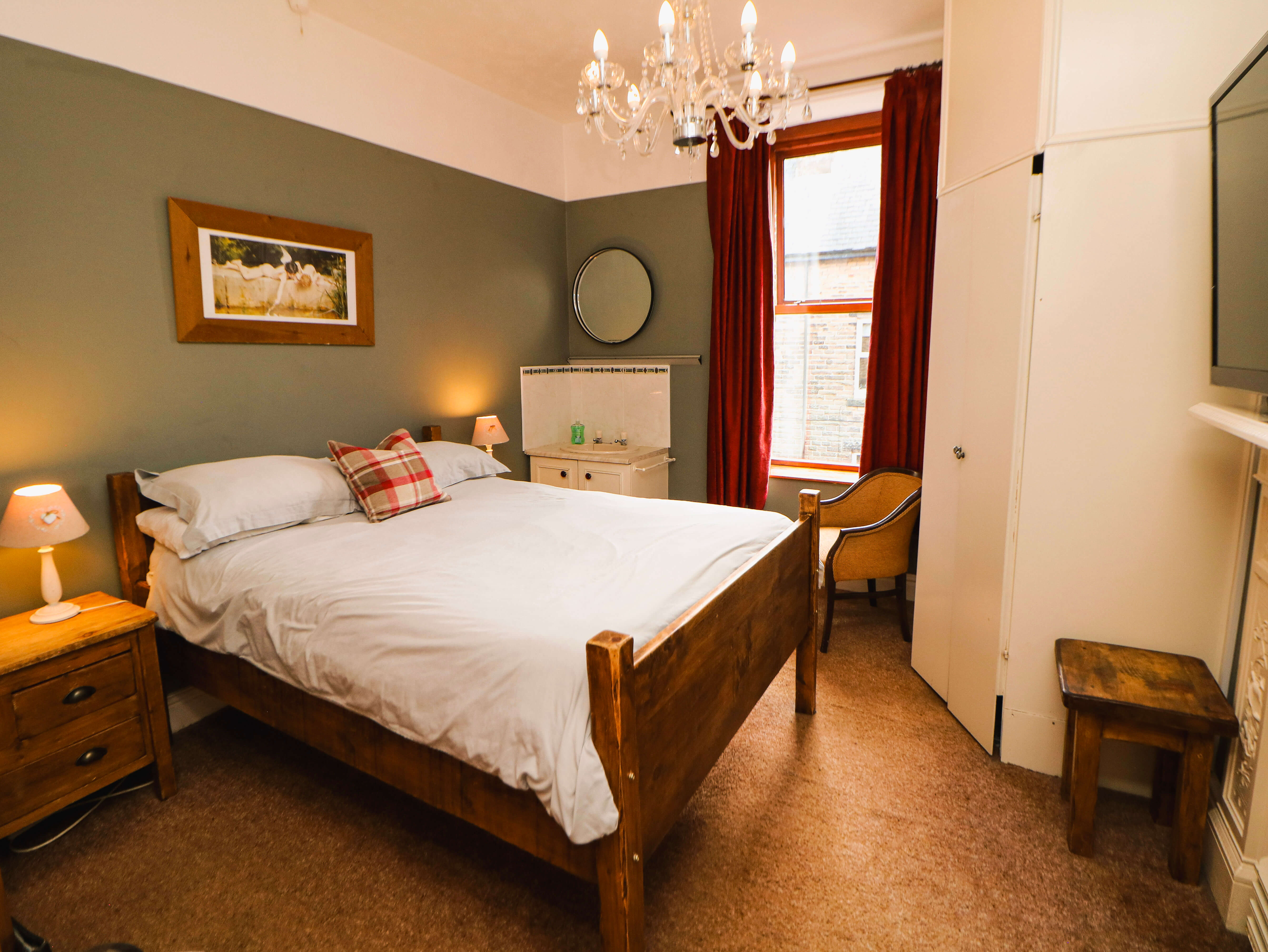 Room 2 double en-suite room at Compton Guest House in Buxton with wooden bed and tall sash window