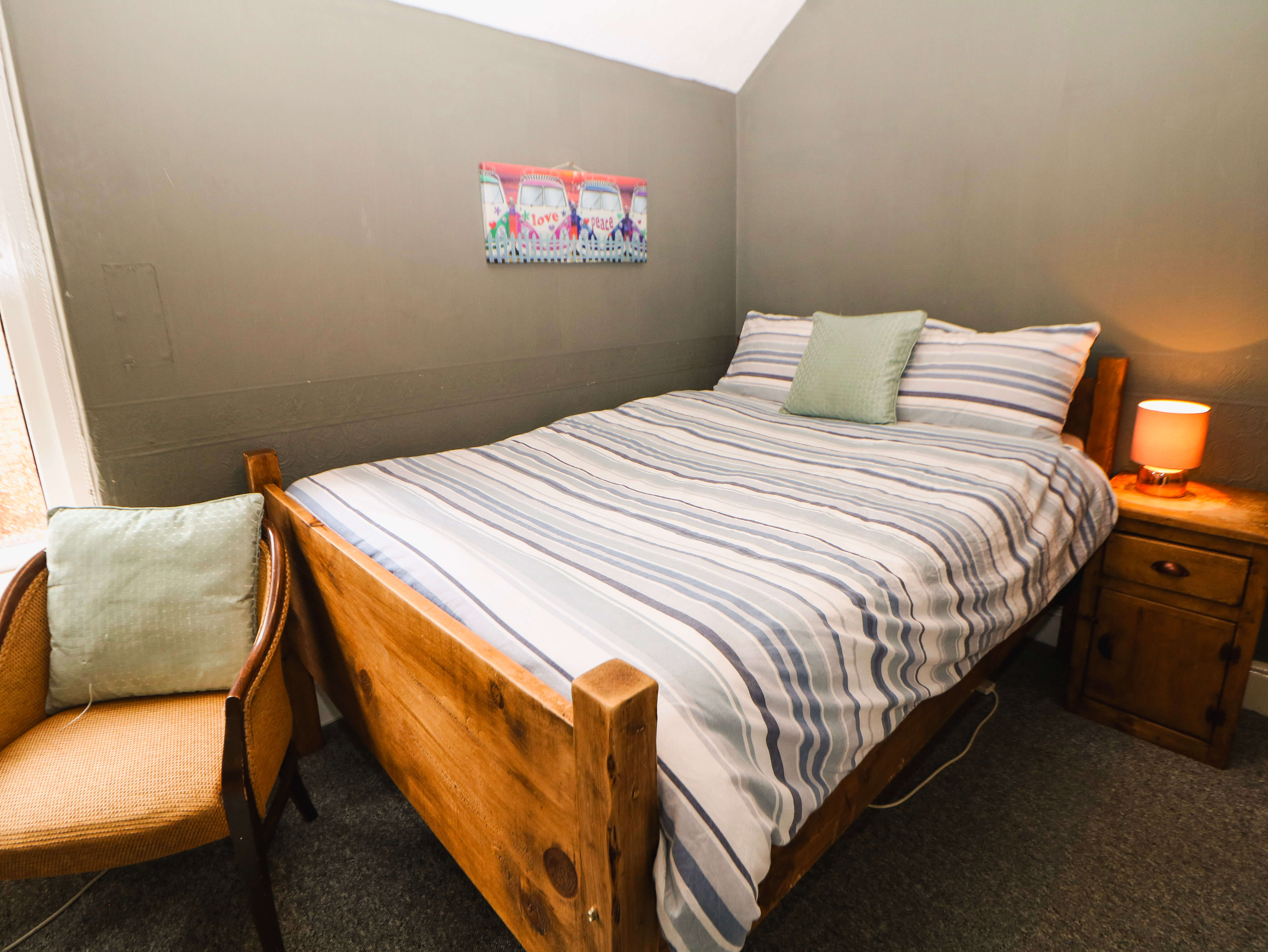 Room 4 single-occupancy guest room at Compton Guest House in Buxton with double-size wooden bed