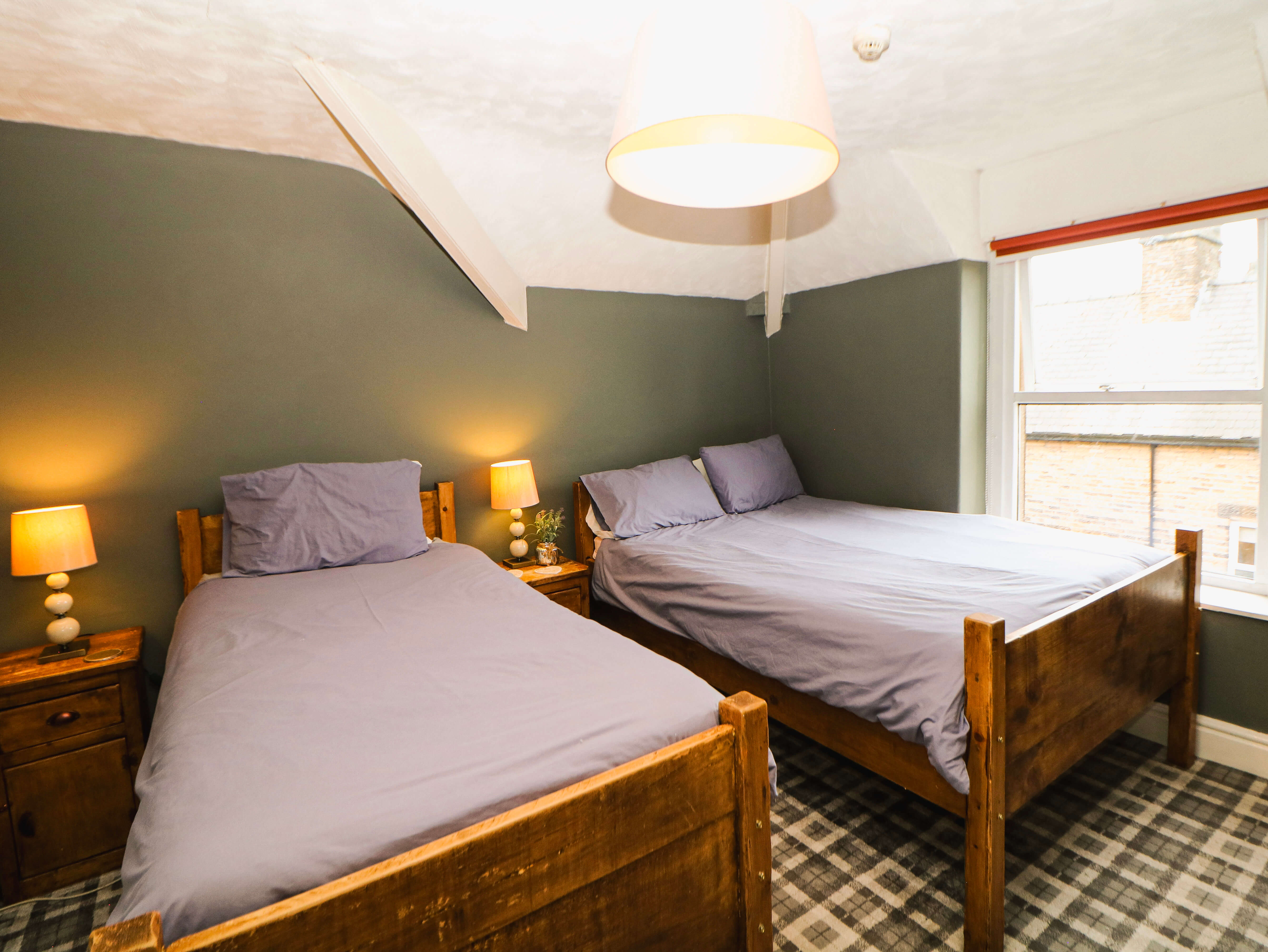 Room 6 twin guest room at Compton Guest House in Buxton with two single wooden beds