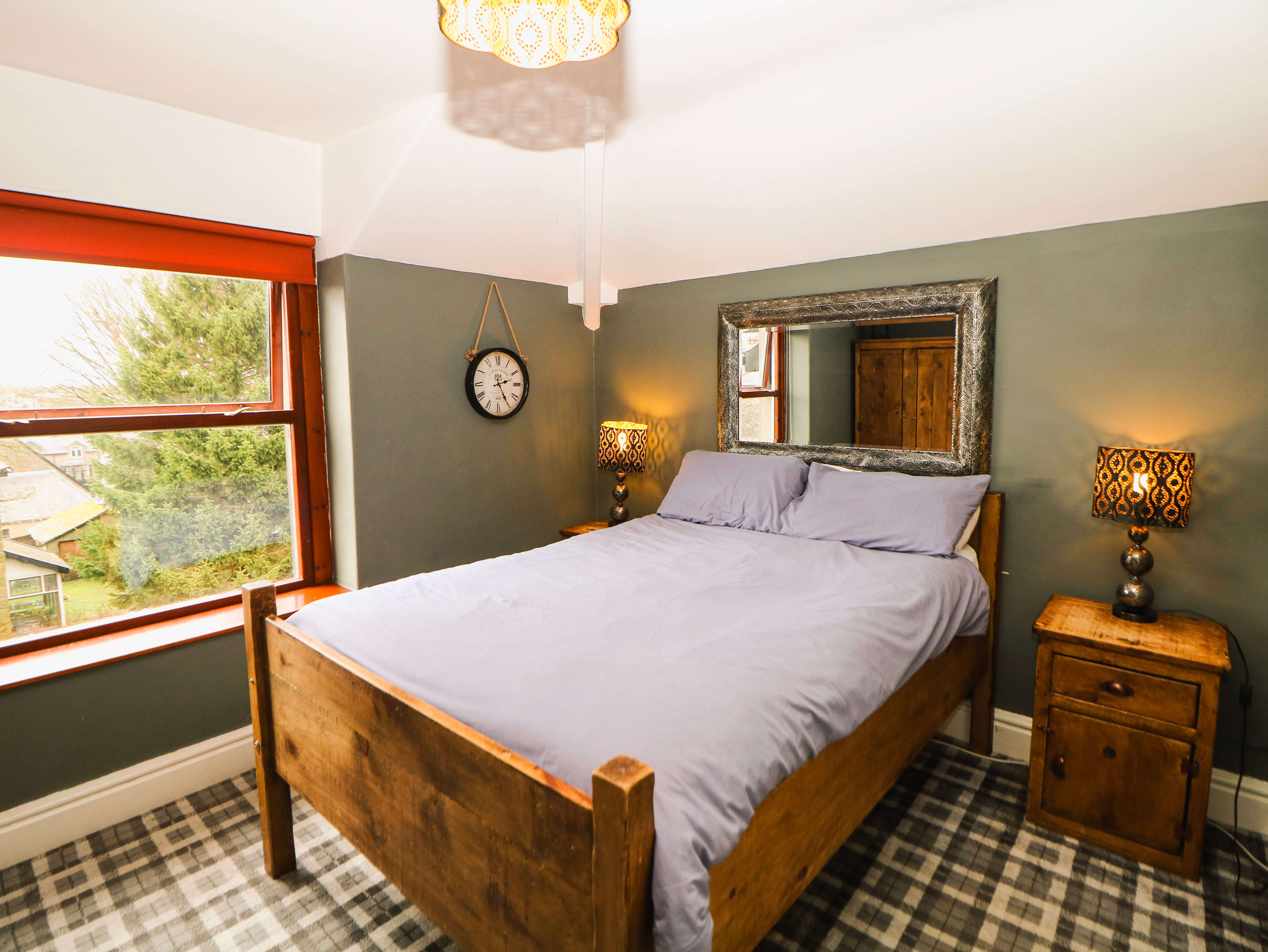 Room 7 double en-suite at Compton Guest House in Buxton with wooden bed and large sash window