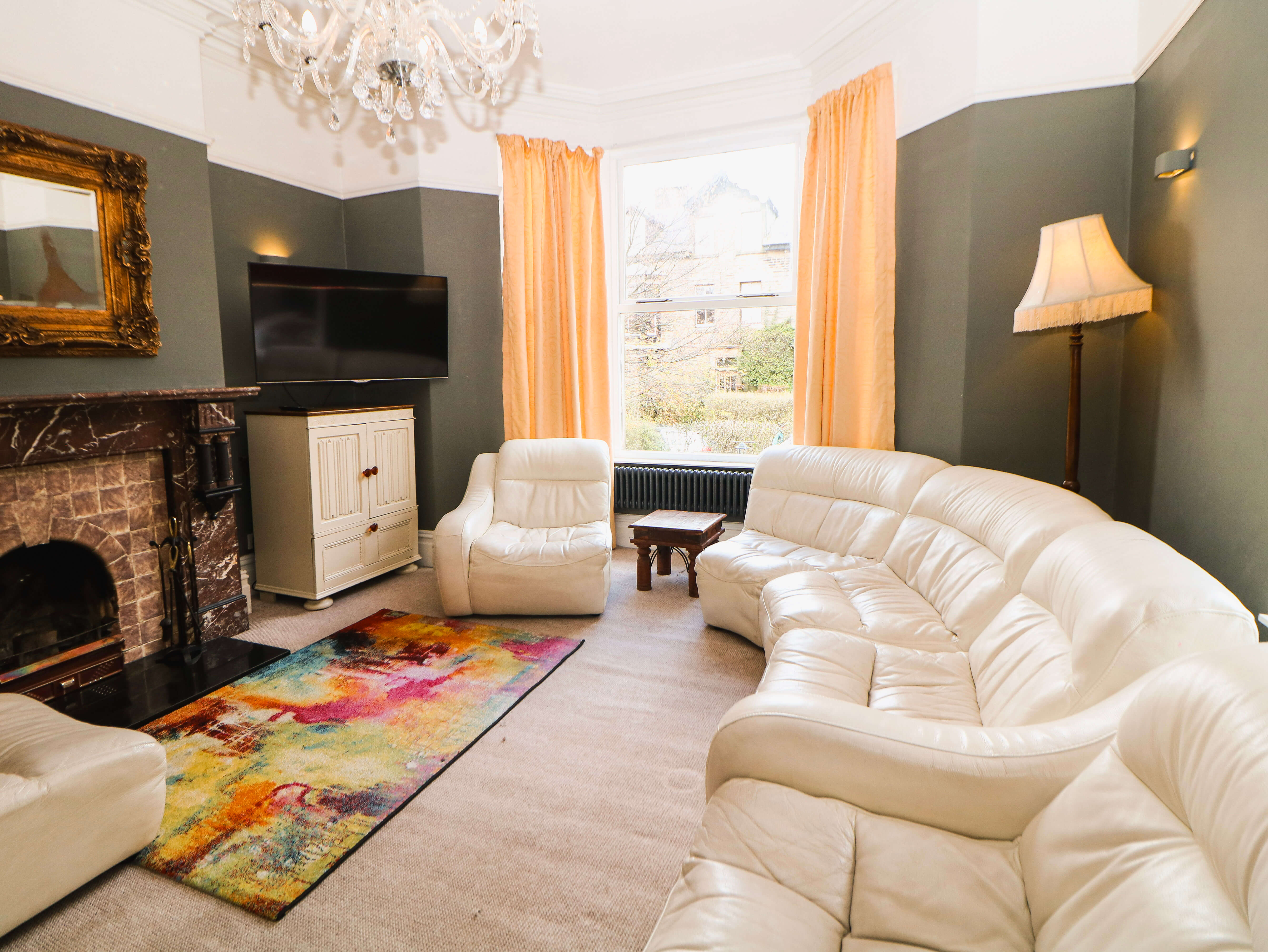 Guest lounge at Compton Guest House in Buxton with Victorian fireplace, bay window and comfortable seating