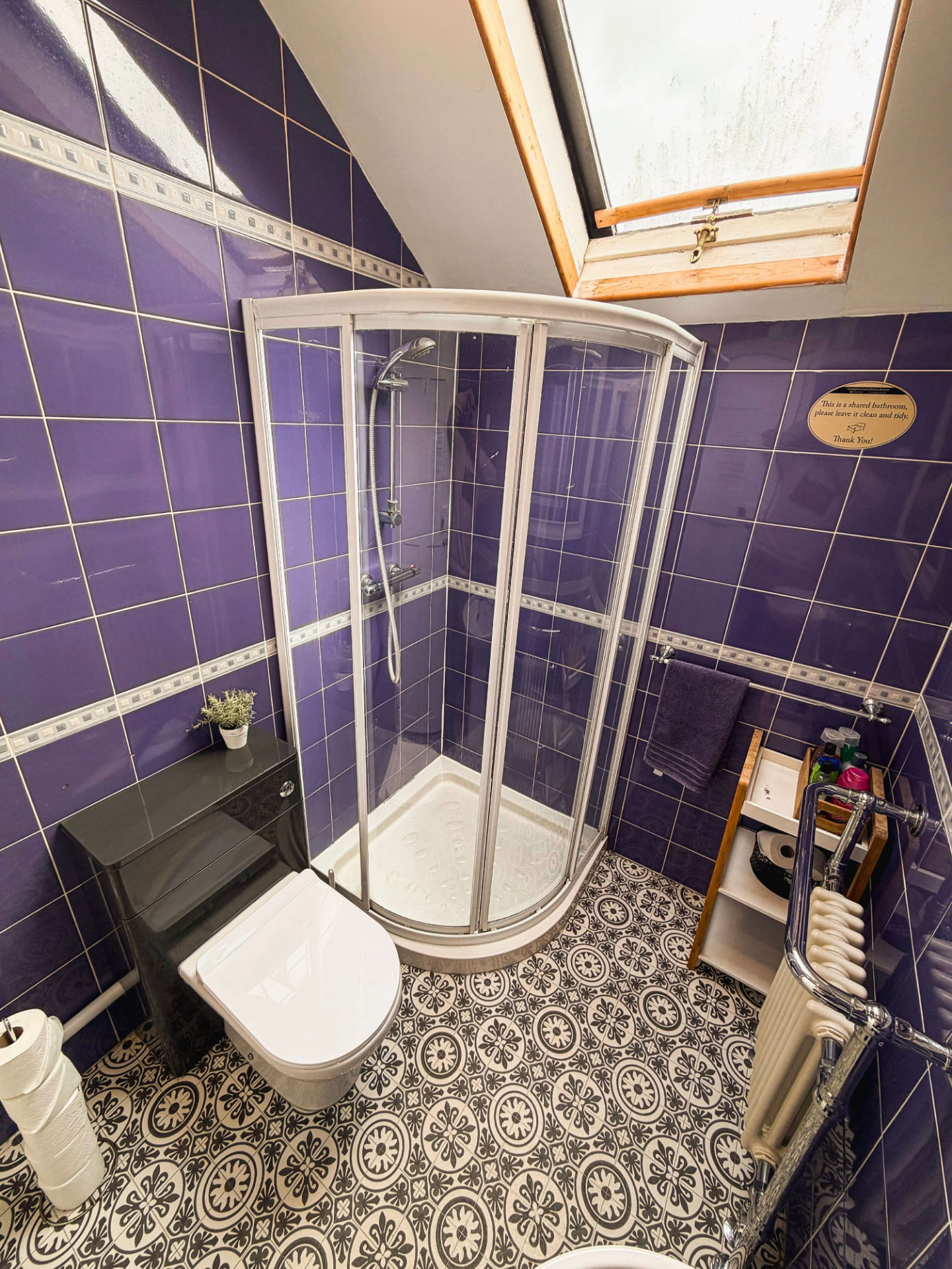 Family bathroom at Compton Guest House with purple tiles, corner shower and patterned floor